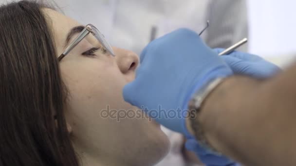 Doctor and nurs starts a dental procedure with young female patient. - Кадри, відео