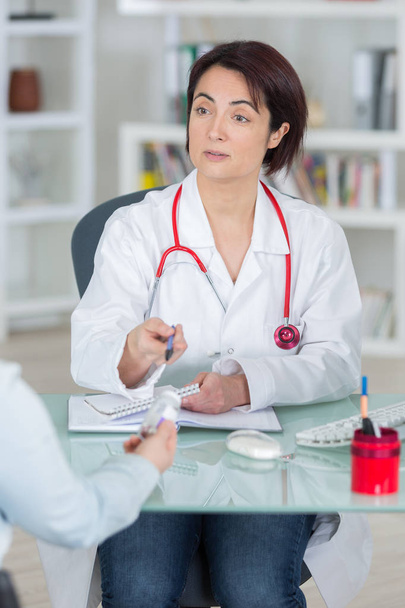 sick woman complaining to doctor about symptoms of malaise - Foto, Imagem
