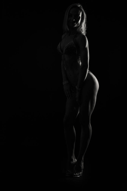 Professional fitness athlete on a black background - Фото, зображення