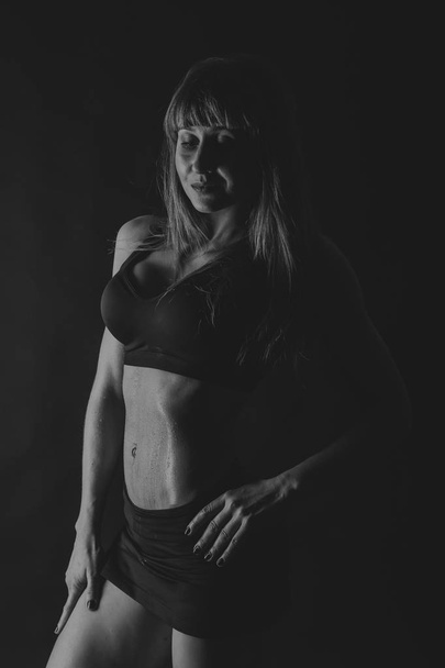weibliche Fitness auf schwarzem Hintergrund - Foto, Bild