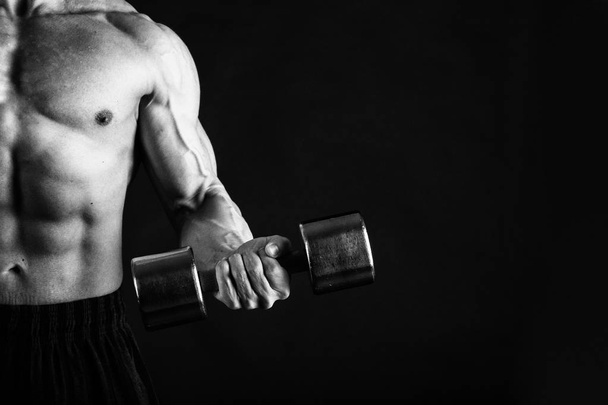Un uomo con un corpo muscoloso splendido su uno sfondo nero
 - Foto, immagini