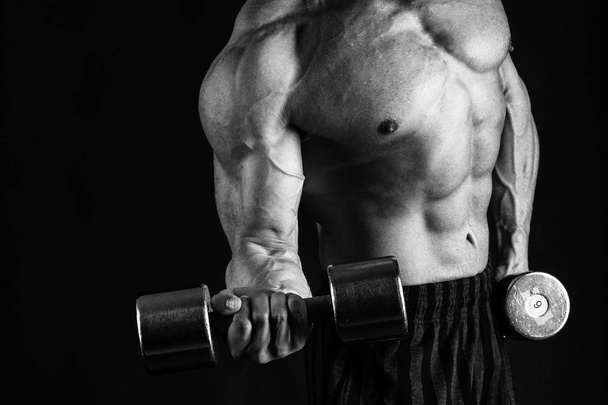 Чоловік з розкішним м'язистим тілом на чорному тлі
 - Фото, зображення