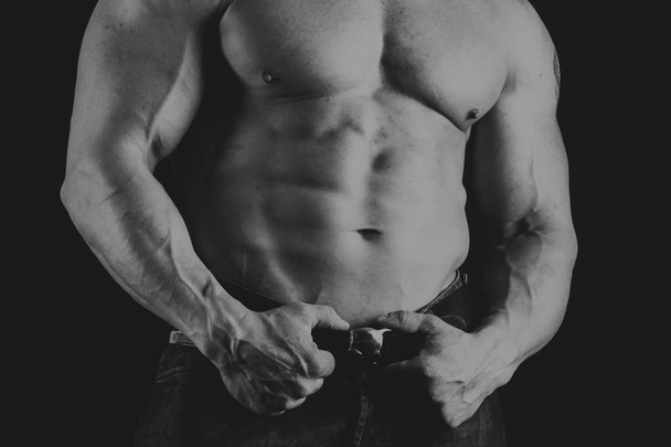 ein Mann mit einem wunderschönen muskulösen Körper auf schwarzem Hintergrund - Foto, Bild