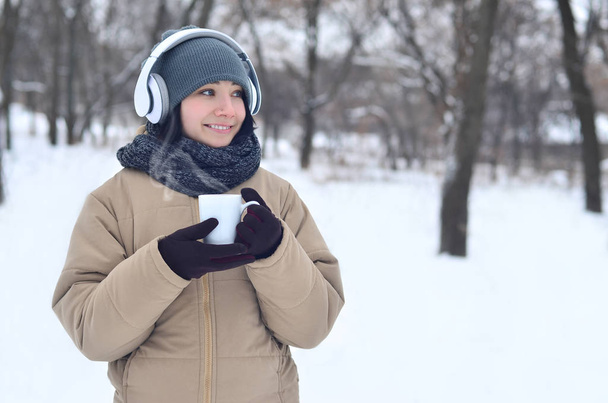 Chica joven con auriculares y taza de café
 - Foto, imagen