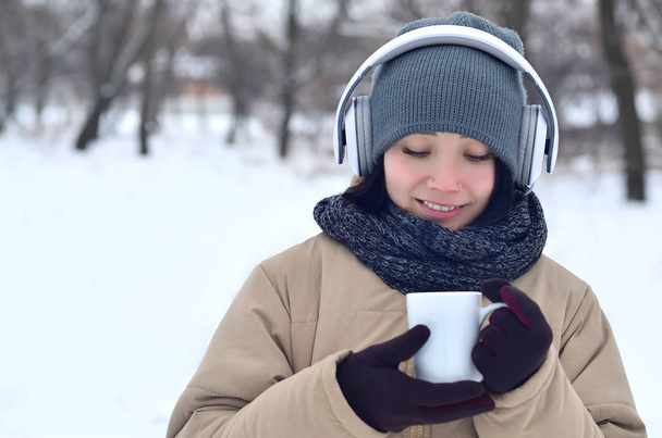 Young girl with headphones and coffee cup - 写真・画像