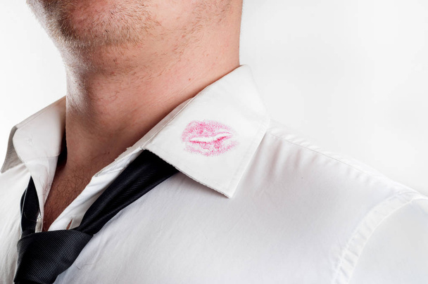Мужчина в белой рубашке, покрытой красными поцелуями помады
 - Фото, изображение