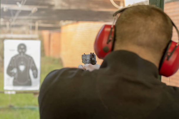 Shooting with a pistol. Man Firing pistol in shooting range. - Foto, Bild