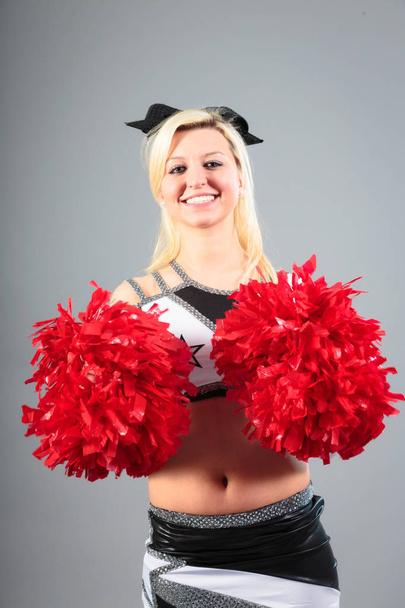 Young Cheerleader On Gray Background - Fotó, kép