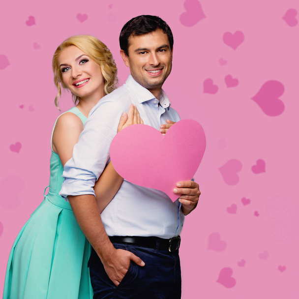 Hermosa pareja sosteniendo corazón rosa
 - Foto, Imagen