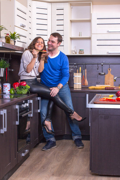 Portrait Of Amorous Couple With food In The Kitchen - Foto, Imagen