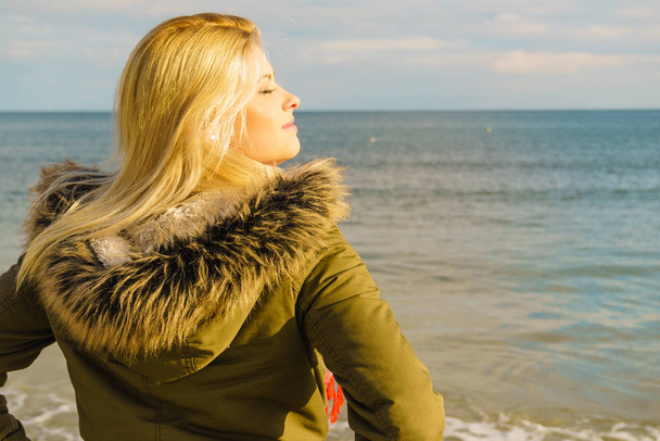 Woman relaxing on beach, cold day - Foto, Bild