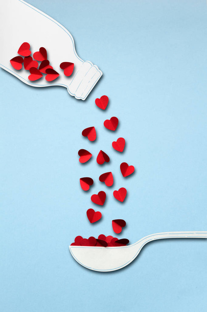 Love brew. Creative valentines concept photo of bottle and spoon made of paper with hearts on blue background. - Photo, image