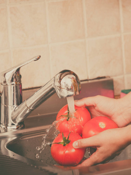 woman washing fresh vegetables in kitchen - Фото, зображення
