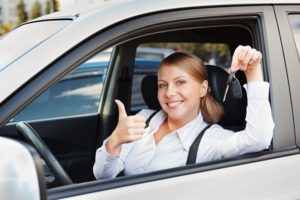 mujer sosteniendo la llave del coche y mostrando los pulgares hacia arriba
 - Foto, Imagen