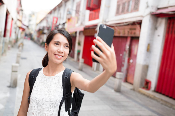 Femme utilisant un téléphone portable pour prendre selfie à Macao
 - Photo, image