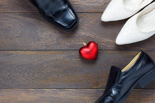  Vue de dessus en forme de coeur avec des chaussures pour hommes et des chaussures pour femmes sur bois
 - Photo, image