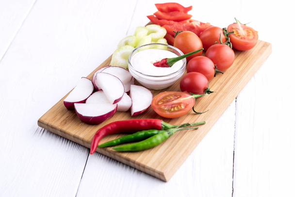 Chopped vegetables served on wooden kitchen board - Foto, afbeelding
