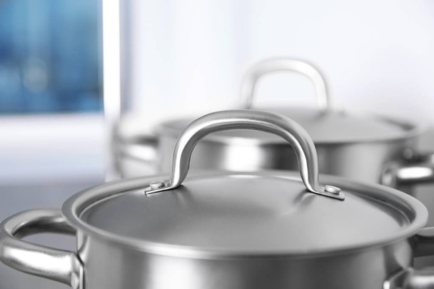 Stainless saucepans on kitchen table - Фото, изображение