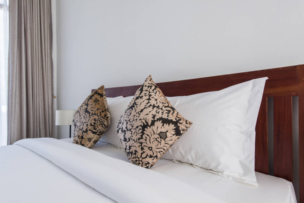 oreillers carrés marron sur un lit double dans la chambre
 - Photo, image