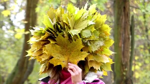 Modell a fején koszorút küld csókolni, és játszik a levelek az erdő. - Felvétel, videó