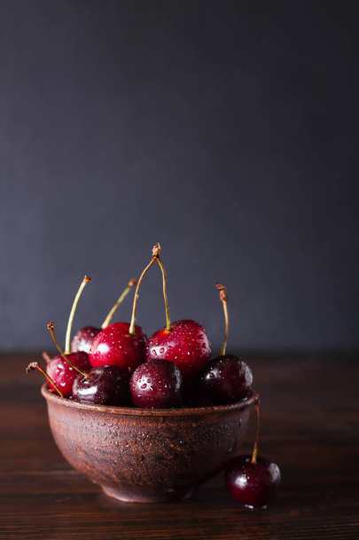 Cherries. Cherry. Cherries in ceramic bowl . Red cherry. Fresh cherries. Cherry on dark background. healthy food concept. Cherries with water drops - Photo, Image