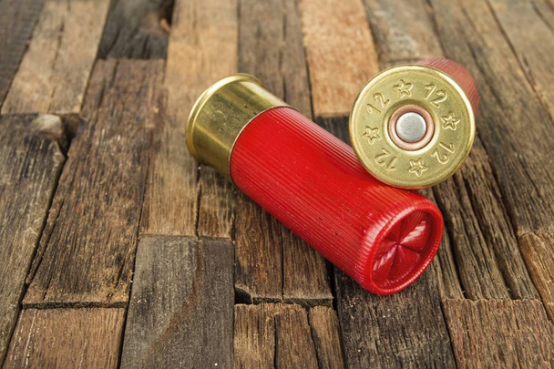 12 gauge red hunting cartridges for shotgun on wooden background. - Foto, immagini