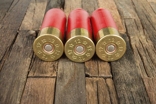 12 gauge red hunting cartridges for shotgun on wooden background. - Valokuva, kuva
