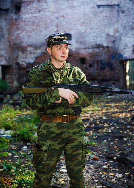 Soldato o miliziano in camuffamento con fucile d'assalto AK-74 in posa in rovina
 - Foto, immagini
