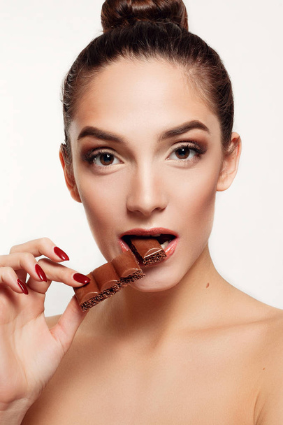 Lovely smiling teenage girl eating chocolate - Photo, image
