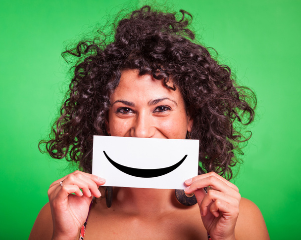 jonge vrouw met smiley emoticon op groene achtergrond - Foto, afbeelding