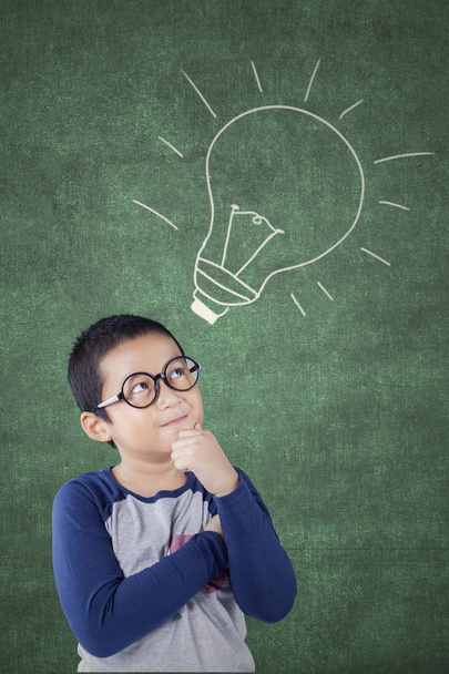 Elementary student looking at lamp on chalkboard - Φωτογραφία, εικόνα