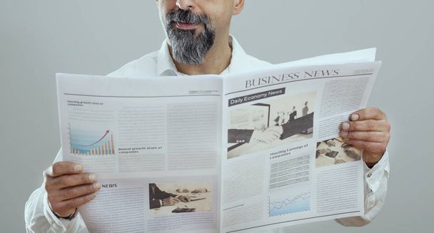 Middle aged man reading newspaper - Photo, Image