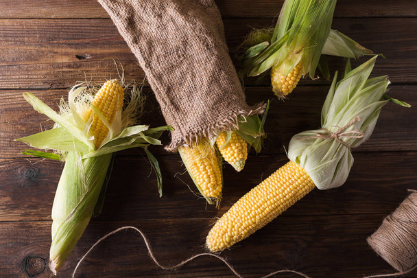 Grains of ripe corn on wooden background - Valokuva, kuva
