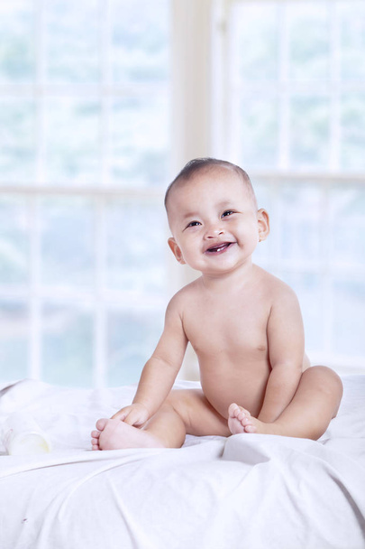 Szép baba nevetve a hálószobában - Fotó, kép