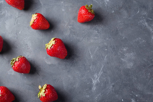 Erdbeere. frische Erdbeere auf dunklem Hintergrund. Rote Erdbeere. lose gelegte Erdbeeren in verschiedenen Positionen. Kopierraum. - Foto, Bild