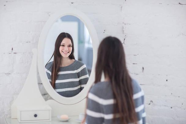 woman looking at reflection in mirror - Zdjęcie, obraz
