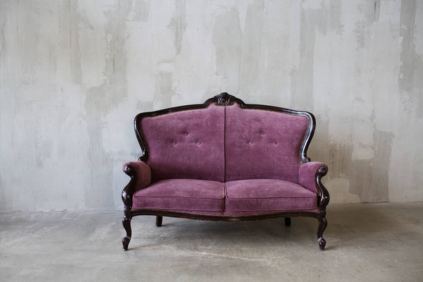 灰色の背景に紫のヴィンテージ ソファー - 写真・画像