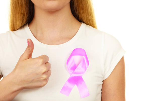 Closeup pink cancer ribbon on woman chest  - Fotoğraf, Görsel