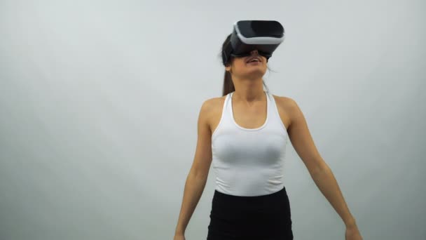 Woman Uses a Virtual Reality Glasses on a White Background - Video, Çekim