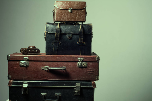 Background stack of old shabby suitcases and camera - Photo, Image