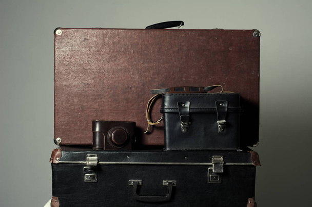 Background stack of old shabby suitcases and the camera - Foto, Imagem
