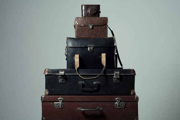 Background stack of old shabby suitcases and camera - 写真・画像