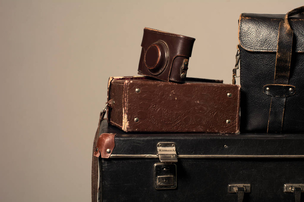 Stack of old shabby suitcase with a camera in bag - Valokuva, kuva