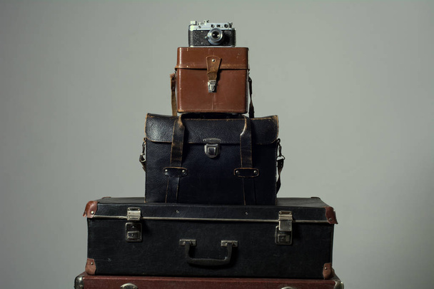 Background stack of old shabby suitcase with a camera in bag. - Fotografie, Obrázek