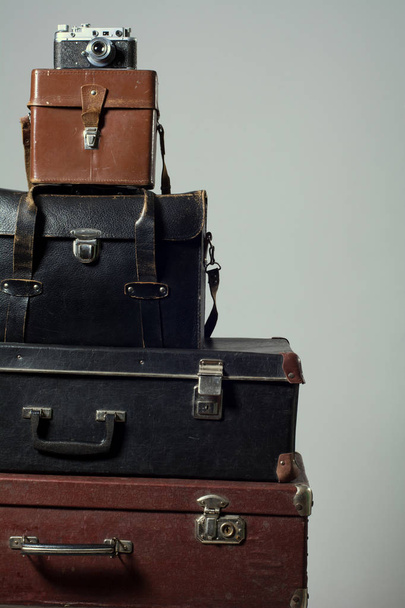 Stack of old shabby suitcases and camera - Foto, Imagem