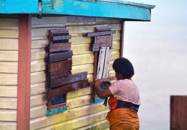 Mujer fiyiana que embarca en su casa durante un ciclón tropical
 - Foto, imagen