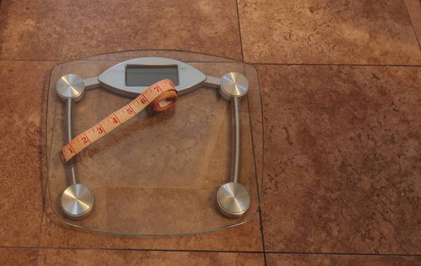 Escala para monitorear el peso con una cinta métrica para tomar medidas
 - Foto, imagen