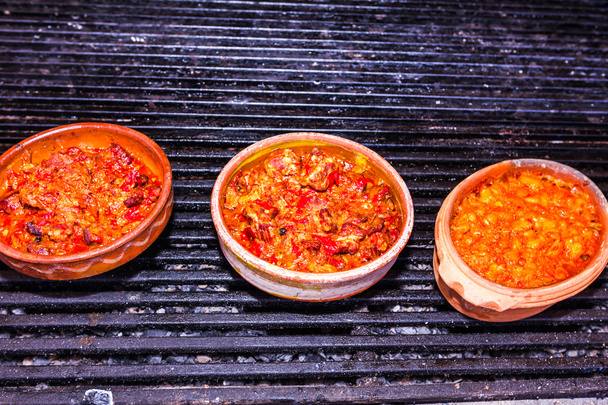 voedsel wordt geserveerd in keramische potten - Foto, afbeelding