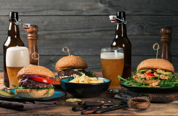 Different burgers, beer snacks with a light beer - Foto, imagen