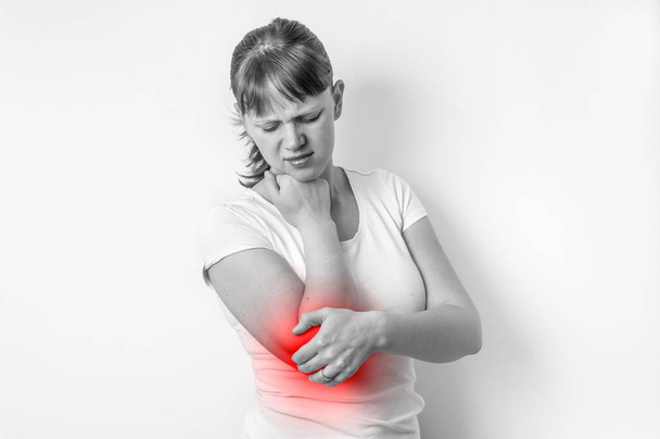 Mulher com dor no cotovelo está segurando seu braço dolorido
 - Foto, Imagem